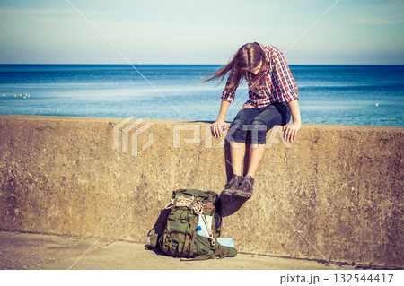 Man tourist backpacker sitting on grunge wall outdoor 132544417