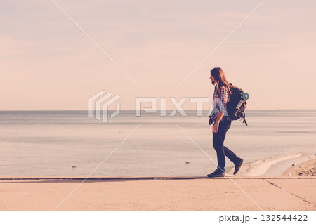 Man hiker with backpack tramping by seaside 132544422