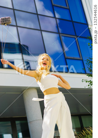 Cheerful fashionable woman in city 132544616