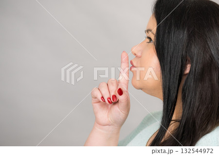 Woman asking for silence with finger on lips 132544972