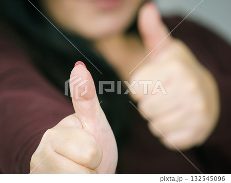 Woman making thumb up gesture 132545096
