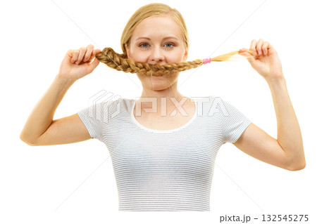 Blonde girl covering her mouth with braid hair Blonde girl covering her mouth with braid hair 132545275