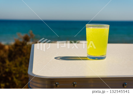 Citrus drink in glass on sea shore 132545541