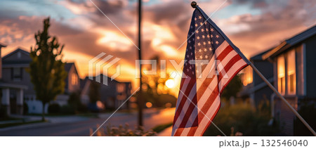American flag waving in suburban neighborhood at sunset 132546040