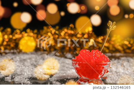 Red caviar in glass bowl with golden spoon on festive background, luxury seafood delicacy served with sparkling holiday lights and golden bokeh, Christmas and New Year celebration concept 132546165