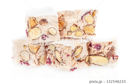Stack of traditional Italian nougat torrone with almonds and dried cranberries isolated on white background, festive sweet dessert concept 132546233