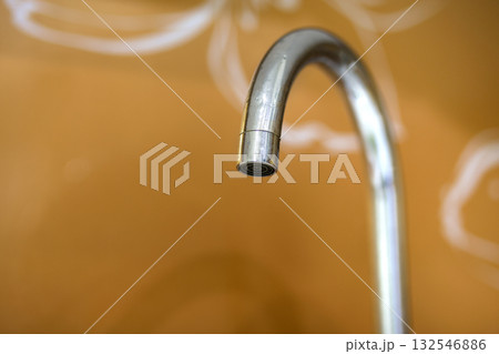 Water tap, chrome stainless metal faucet in bathroom or kitchen, mixer cold hot water isolated on bright yellow copy space background. Modern kitchen interior. Water tap, chrome stainless metal faucet in bathroom or kitchen, mixer cold hot water isolated on bright yellow copy space background. Modern kitchen interior. 132546886
