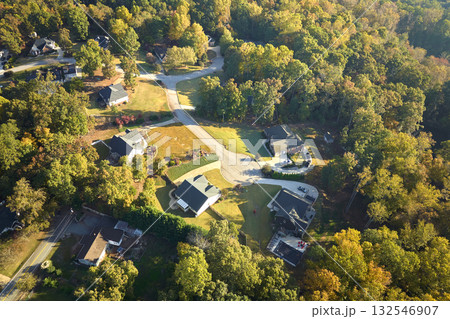 View from above of expensive residential houses between yellow fall trees in suburban area in South Carolina. American dream homes as example of real estate development in US suburbs 132546907