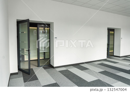 Empty office space With Two Doors and a Checkered Floor Empty office space With Two Doors and a Checkered Floor 132547004