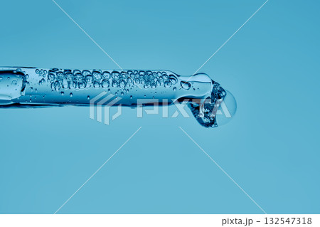 A serum pipette with lots of bubbles on a blue background. A serum pipette with lots of bubbles on a blue background. 132547318
