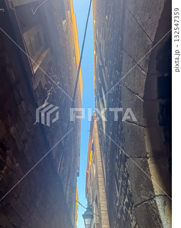 Narrow Stone Alleyway between Old Buildings in Historic City 132547359