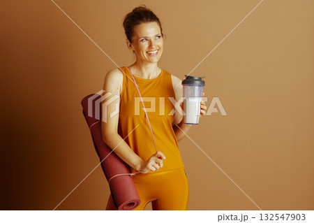 Cheerful Woman with Yoga Mat and Protein Drink Cheerful Woman with Yoga Mat and Protein Drink 132547903