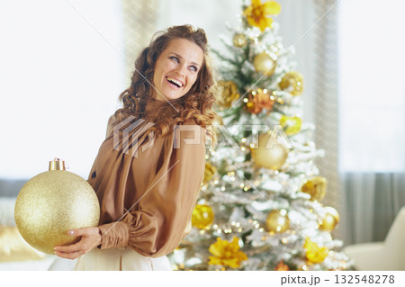 Cheerful Woman Decorates Flocked Christmas Tree 132548278