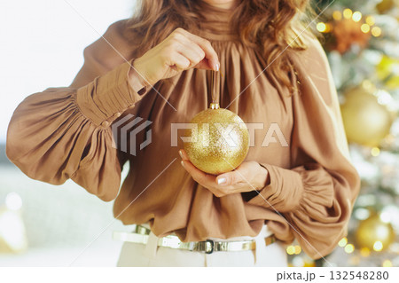Woman\'s Hands with a Sparkling Gold Christmas Ornament Woman\'s Hands with a Sparkling Gold Christmas Ornament 132548280