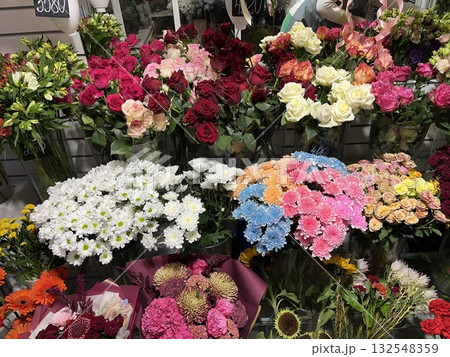 Colorful assortment of fresh flowers including roses, daisies, and carnations arranged beautifully in a floral shop, showcasing vibrant hues and natural beauty for decoration or gifting 132548359