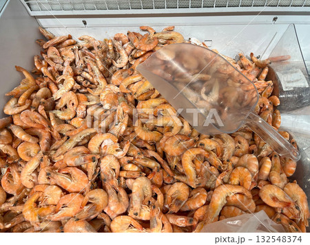 Freshly caught shrimp piled high in a seafood display, showcasing vibrant colors and textures, with a clear scoop resting on top for easy serving and selection Freshly caught shrimp piled high in a seafood display, showcasing vibrant colors and textures, with a clear scoop resting on top for easy serving and selection 132548374