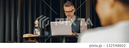 Focused Professional Working in Modern Caf Focused Professional Working in Modern Caf 132548602