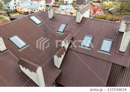 Roof of a house made from metal sheets with attic windows. Roof of a house made from metal sheets with attic windows. 132548634