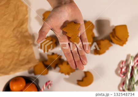Hand Holds Tree Shaped Gingerbread Cookie During Christmas Celebration 132548734