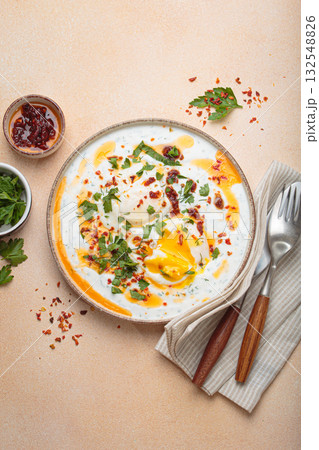 Turkish eggs cilbir, Middle Eastern style breakfast on beige background table top view Turkish eggs cilbir, Middle Eastern style breakfast on beige background table top view 132548826