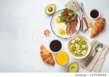 Breakfast white table fried eggs vegetables salad, oats fruit, croissants, coffee, juice healthy copy space. 132548846