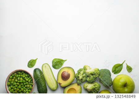 Fresh green vegetables and fruit white background top view, diet, vegetarian healthy food copy space Fresh green vegetables and fruit white background top view, diet, vegetarian healthy food copy space 132548849