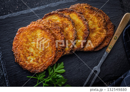 Fried potato pancake on black table. Fried potato pancake on black table. 132549880