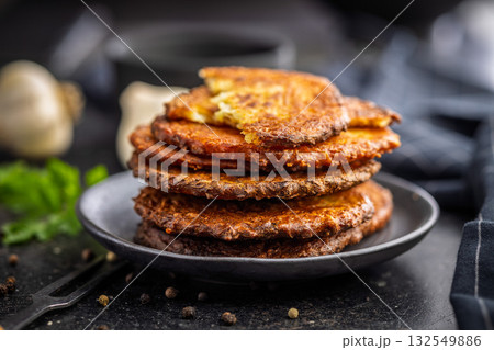 Fried potato pancake on plate on black table. Fried potato pancake on plate on black table. 132549886