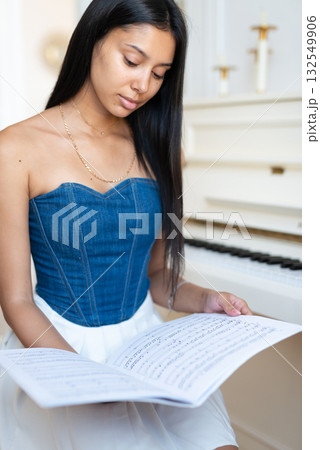 Student musician at the piano preparing for the lesson Student musician at the piano preparing for the lesson 132549906