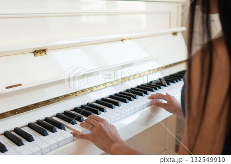 A woman plays the piano A woman plays the piano 132549910