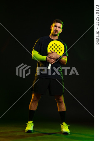 Man poses with a paddle in a dramatic lighting setup during a sports session Man poses with a paddle in a dramatic lighting setup during a sports session 132550173