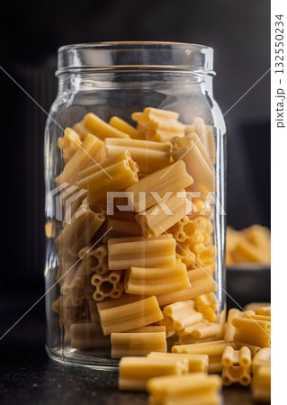 Cinque buchi. Uncooked italian pasta on black table. Cinque buchi. Uncooked italian pasta on black table. 132550234