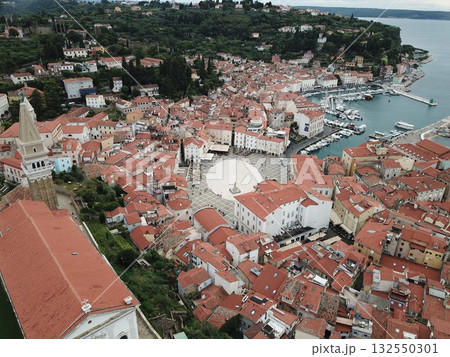 Piran old town buildings with red roofs, Tartini square, and harbor marina with boats in Adriatic sea coastline Piran old town buildings with red roofs, Tartini square, and harbor marina with boats in Adriatic sea coastline 132550301