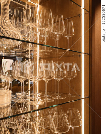 elegant bar display, refined stemware presentation on backlit glass shelves for upscale venues 132550671