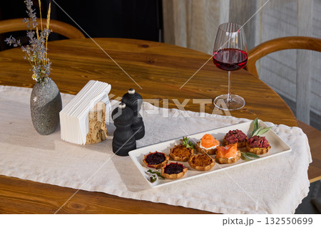 An Elegant Table Setting Featuring Gourmet Appetizers Accompanied by Fine Wine Selection An Elegant Table Setting Featuring Gourmet Appetizers Accompanied by Fine Wine Selection 132550699