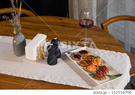 An Elegant Table Setting with a Variety of Appetizers Accompanied by Fine Red Wine Choices An Elegant Table Setting with a Variety of Appetizers Accompanied by Fine Red Wine Choices 132550700