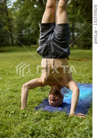 Performing a Dynamic Handstand on the Grass Engaging in Outdoor Fitness and Yoga Practice Performing a Dynamic Handstand on the Grass Engaging in Outdoor Fitness and Yoga Practice 132550820