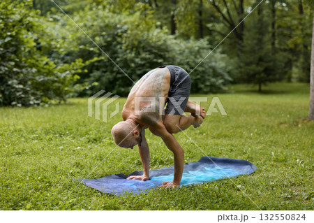 An Athletic Individual Engaging in Yoga Pose Amidst a Serene and Peaceful Park Setting 132550824