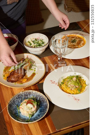 A gourmet dinner table setting with diverse dishes and elegant presentation to delight the senses 132550835