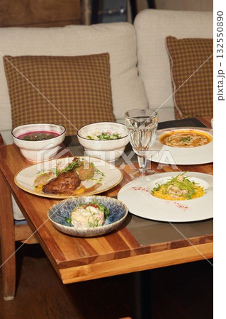Exquisite and beautifully presented dishes are elegantly displayed on a wooden table Exquisite and beautifully presented dishes are elegantly displayed on a wooden table 132550890
