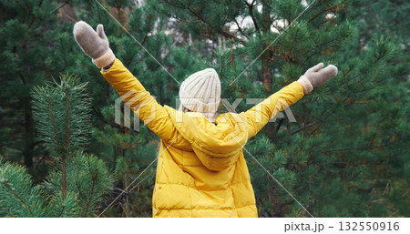 Winter day, happy young woman enjoys snow, warm weather against Christmas tree in snowy green forest Winter day, happy young woman enjoys snow, warm weather against Christmas tree in snowy green forest 132550916