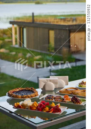 A Beautiful Spread of Desserts and Fresh Fruits Set Against a Scenic Background 132550932