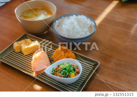 焼き鮭と卵焼き、かぼちゃの煮物と納豆を添えた和定食スタイルの朝食 焼き鮭と卵焼き、かぼちゃの煮物と納豆を添えた和定食スタイルの朝食 132551315