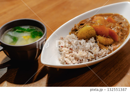 野菜たっぷりのカレーライスとスープを添えた家庭的な夕食 野菜たっぷりのカレーライスとスープを添えた家庭的な夕食 132551387