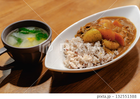 野菜たっぷりのカレーライスとスープを添えた家庭的な夕食 132551388