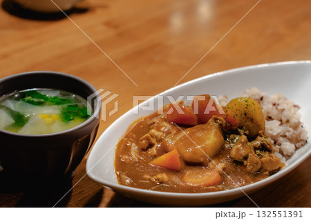 野菜たっぷりのカレーライスとスープを添えた家庭的な夕食 野菜たっぷりのカレーライスとスープを添えた家庭的な夕食 132551391