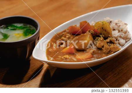 野菜たっぷりのカレーライスとスープを添えた家庭的な夕食 野菜たっぷりのカレーライスとスープを添えた家庭的な夕食 132551393