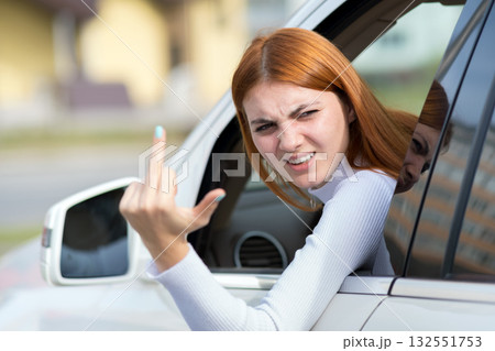 Pissed off displeased angry aggressive woman driving a car shouting at someone with middle finger gesture. Pissed off displeased angry aggressive woman driving a car shouting at someone with middle finger gesture. 132551753
