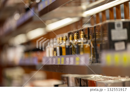 perfume bottles displayed on a brightly lit shelf in a store perfume bottles displayed on a brightly lit shelf in a store 132551917