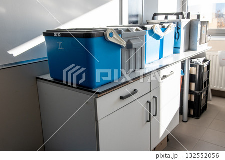 Blue plastic storage boxes on a laboratory counter.Automatic sampler equipment in laboratory setting. Blue plastic storage boxes on a laboratory counter.Automatic sampler equipment in laboratory setting. 132552056